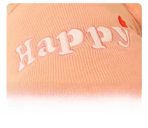 Detailed macro view of the knitted texture and happy letter embroidery on the plush toy