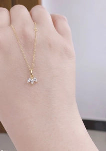 Detailed close-up of a gold S925 sterling silver necklace with three marquise cut diamonds