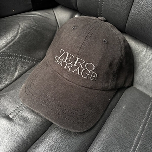 Detail of white ZERO GARAGE embroidery on a black cotton canvas baseball cap