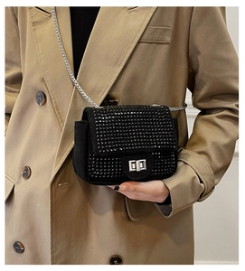 Detailed close-up of a black rhinestone crossbody bag with a silver metal turn-lock