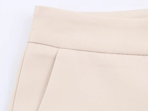 Detailaufnahme des beigen Strukturgewebes mit präzisen Nähten und Taschendetails am Anzug