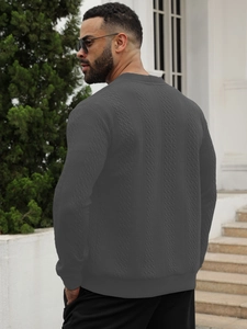 Détail d'un pull en maille gris foncé pour homme avec texture torsadée et coupe décontractée