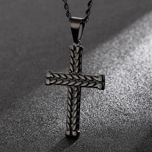 Macro shot of black stainless steel cross pendant with textured woven design and rope chain