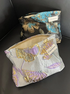 Detail view of woven brocade cosmetic bags with zipper and jacquard floral patterns