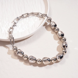 Minimalist silver asymmetric necklace with irregular beads and chunky chain links on tray