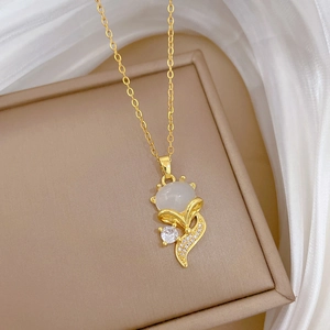Close-up of golden fox pendant with white cat-eye stone and sparkling zircons