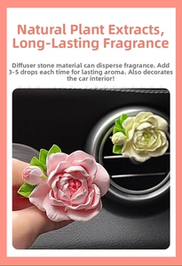 Close-up of white and pink flower-shaped ceramic car diffusers on air vent clip