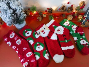 Detail of soft coral fleece Christmas socks featuring festive Santa and snowflake patterns