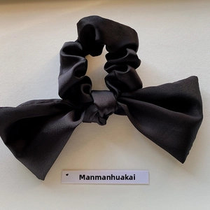 Elegant black satin bow hair scrunchie shown on a minimalist white background with card