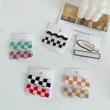 Close-up of stylish knit pattern hair clips in checkered and wavy colorful designs