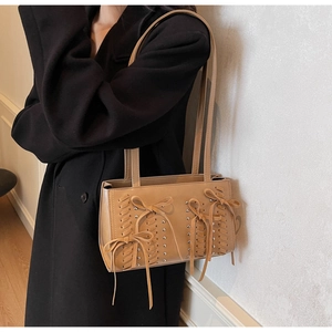 Detail of khaki PU shoulder bag with decorative woven texture and three hanging bows