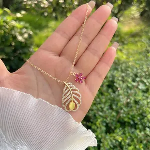 Dettaglio della collana con ciondolo a foglia in oro 18K con zirconi e ciondolo a fiore