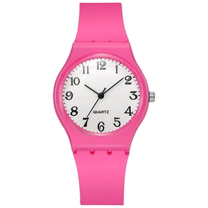Detail view of pink silicone quartz watch with white dial and numeric markers