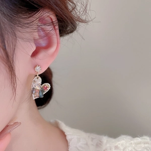 Detail shot of heart-shaped earrings featuring multicolor zircon stones and gold finish