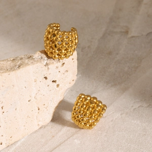 Macro detail of 18k gold plated steel beads ear cuff with honeycomb woven texture