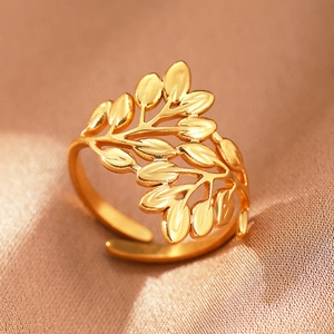 Macro detail of Bohemian golden leaf pattern open ring on warm silk fabric background