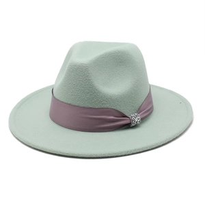 Detailed close-up of light green wool fedora hat with satin ribbon and rhinestone buckle