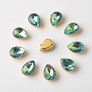 Detail of 10x14mm teal pear-shaped rhinestones with gold prong settings and sew-on holes