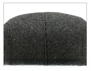 Macro shot of stitching craft and grey herringbone weave texture on the elderly men's cap