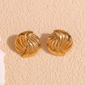 Dettaglio macro degli orecchini a spirale placcati oro con texture intrecciata 3D