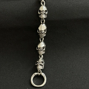 Close-up of silver skull link bracelet with vintage metal texture and O-ring clasp