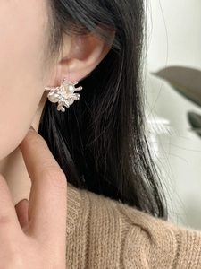 Close-up of elegant 18k gold plated silver earrings with pearls on female model