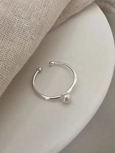 Macro shot of minimalist S925 sterling silver ring with a white freshwater pearl detail