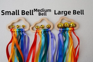 Detailed macro view of wooden cloud baby rattles with golden bells and rainbow ribbons