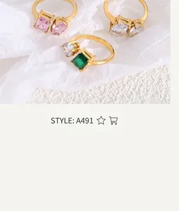 Detailed view of three gold-plated titanium rings with emerald and pink teardrop crystals