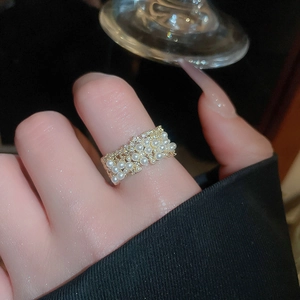 Macro shot of gold cluster ring with pearls and pavé cubic zirconia for women