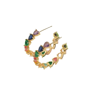Gold C-shaped hoop earrings with colorful heart-shaped zircons on white background