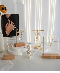 Detail of elegant gold jewelry set with pearls and butterfly pendants on display stand