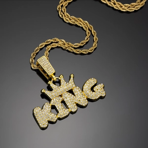 Macro shot of gold hip hop KING pendant with crown and shiny full zircon micro-pave