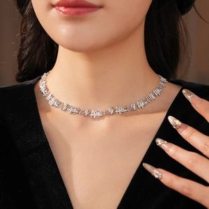 Close-up of elegant silver necklace with square zircon stones worn by a model