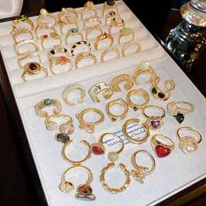 Detailed view of gold dragon-shaped open rings with zircon and pearl on a jewelry tray