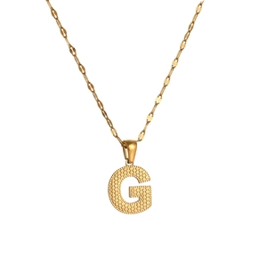 Detailed view of golden letter G pendant with unique dotted texture and delicate chain