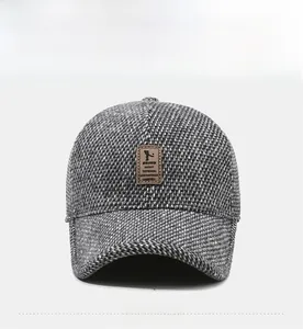 Detailed macro view of the grey knit texture and embossed leather label on the winter cap