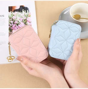 Detailed view of pink and light blue quilted mini makeup pouches with gold zippers
