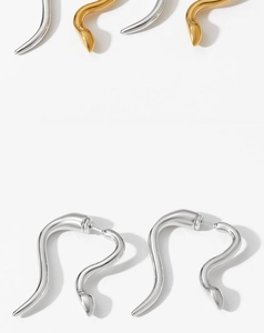 Minimalist snake-shaped earrings in polished gold and silver finish on white background
