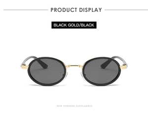 Front view of black and gold oval sunglasses with dark lenses on white background