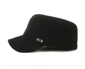Detail view of the silver metal T-S brand tag on a black winter flat top cap