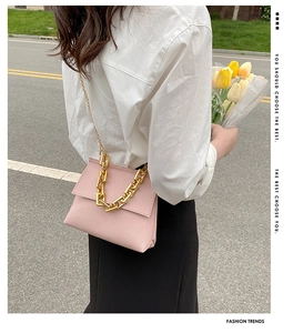 Détail du sac à main rose texture litchi avec bandoulière élégante en chaîne dorée chic