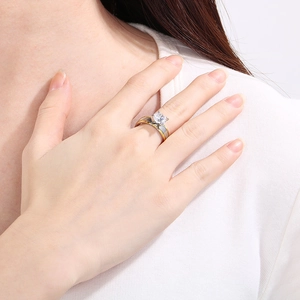 Détail d'une bague bicolore à bande torsadée avec zircon sur la main d'un mannequin