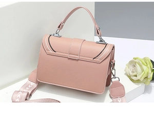 Detailed view of pink crossbody bag with scalloped stitching and detachable shoulder strap