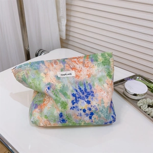 Detailed shot of the floral cotton makeup bag featuring watercolor prints and brand label