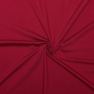 Gros plan sur la texture du tricot rouge avec détails drapés de la robe moulante