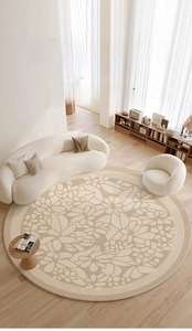 Detailed top view of a round woven beige rug with floral patterns in a minimalist room