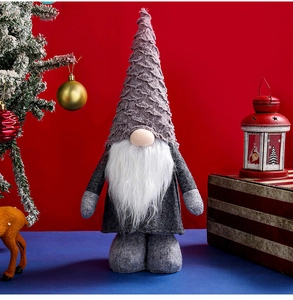 Detail of gray Nordic Christmas gnome with knitted hat and plush beard on festive background