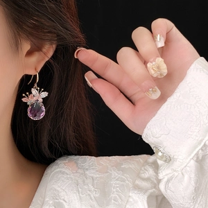 Elegant gold butterfly waterdrop earrings featuring purple crystals and zircons on model