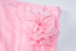 Close-up of pink tube top set showing 3D mesh floral detail and smooth fabric texture